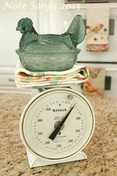 an old fashioned kitchen scale with a chicken on top