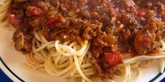 a white plate topped with spaghetti and meat