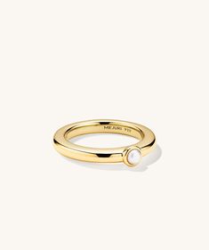 a gold ring with a pearl on the side and a small white pearl in the middle