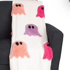 a white blanket with pink and purple ghost faces on it