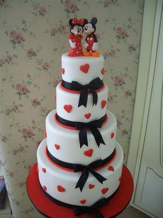 a three tiered cake with mickey and minnie on top