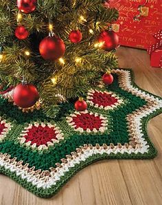 a crocheted christmas tree skirt with ornaments on it