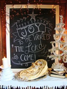 a chalkboard with words written on it next to a christmas tree and other decorations