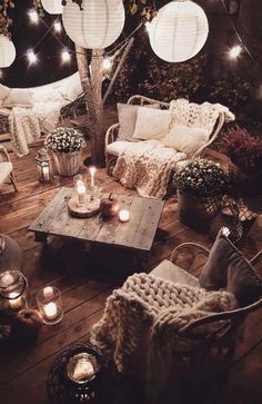 an outdoor living room is lit up with candles