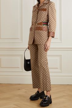 This jacket incorporates a number of the Gucci's signature emblems as a tribute to the archives and traditions of the house. It's made from cotton-blend canvas jacquard-woven with the monogram, which is also featured on the gold-tone buttons. Trimmed in tan leather, it has a slim silhouette with padded shoulders and an elasticated webbing belt with red and green stripes, as well as the recognizable horse bit. Wear yours with the matching pants. Leather Leggings Gucci Sneakers, Luxury Gucci Short Sleeve Shirt, Luxury Monogram Print Collared Top, Gucci Luxury Short Sleeve Shirt, Luxury Fitted Bandhgala With Dabka Work, Luxury Fitted Bandhgala With Dabka Details, Luxury Traditional Bandhgala With Dabka, Luxury Graphic Print Blouse For Workwear, Luxury Fall Outerwear With Baseball Collar