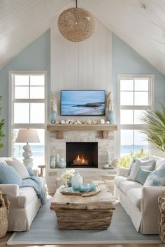 Coastal living room featuring an electric fireplace with a TV above and stylish wall storage, creating a harmonious decor. Electric Fireplace Ideas With Tv Coastal, Beach Cottage Fireplace Ideas, Fireplace On Window Wall, Beach House Tv Wall, Coastal Stone Fireplace, Coastal Living Room Tv, Coastal Fireplace Ideas Beach Styles, Fireplace Beach House, Coastal Tv Room