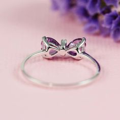 "The perfect dainty ring to add to your everyday outfit, as well as a great gift for any occasion. This bow ring can either be worn on its own, or you can even stack it with your other favorite pieces. The ring features both cubic zirconia and amethyst stone. Available in multiple sizes listed down below. The ring is made with sterling silver which means it is hypoallergenic. The material makes it perfect for everyday wear because sterling silver is durable and can take rough and tough wear. Wha Delicate White Gold Crystal Ring As Gift, Delicate Cubic Zirconia Crystal Ring As A Gift, Delicate Silver Diamond Ring For Gift, Delicate White Gold Stackable Rings As Gift, Delicate White Gold Stackable Rings For Gift, Delicate Sterling Silver Butterfly Ring Gift, Dainty Cubic Zirconia Stackable Rings As Gift, Dainty Cubic Zirconia Rings For Gift, Dainty Cubic Zirconia Rings As Gifts