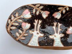 two giraffes are depicted in this decorative dish