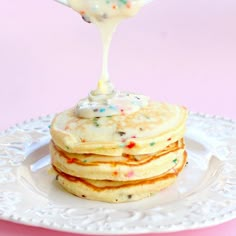 a stack of pancakes with icing and sprinkles