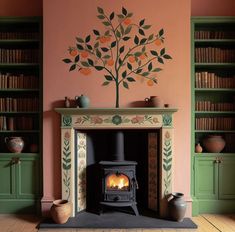 a fireplace in a room with bookshelves and a tree painted on the wall