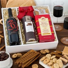 two bottles of wine, crackers and cookies on a table