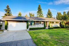 a house that has grass in front of it and trees around the back yard area