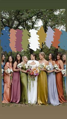 a group of women standing next to each other in front of a tree with colorful paint swatches