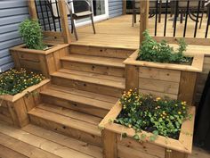 wooden steps with planters and flowers in them on the decking area outside a house