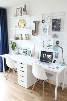 a white desk topped with a laptop computer next to a wall mounted shelf filled with pictures