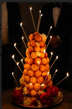 there is a cake made out of donuts with candles in the shape of a pyramid