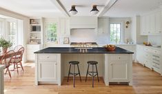 a kitchen with white cabinets and black counter tops