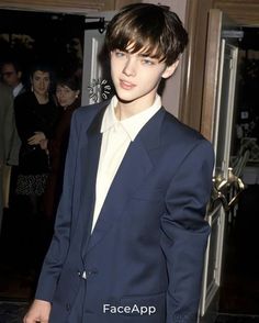 a young man in a blue suit and white shirt