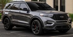 a grey ford explorer parked in front of a building