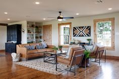 a living room filled with lots of furniture and decor on top of a hard wood floor