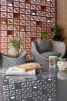 two chairs sitting next to each other near a table with books and cups on it