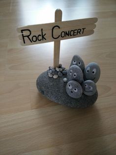 a rock with some rocks on it and a sign that says rock concert