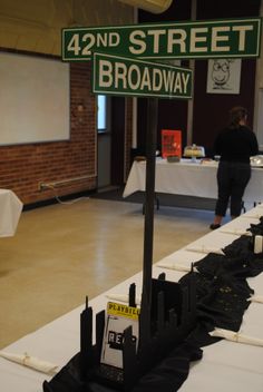 a street sign sitting on top of a table covered in black cloths and white tablescloths