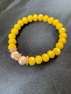 Introducing our stunning Yellow Faceted Rondelle Glass Bracelet, a must-have addition to any jewelry collection. This beautifully crafted piece features a series of yellow glass beads that have been expertly cut into a Rondelle shape, creating a faceted surface that catches the light with every movement. The bright and sunny yellow color of the beads adds a cheerful touch to any outfit, making it perfect for wearing during the summer months. Yellow Bracelet, Happy Birthday Mom, Sunny Yellow, Glass Bracelet, Bracelet Beaded, Teacher Appreciation Gifts, Yellow Color, Pearl Bracelet, Pearl White