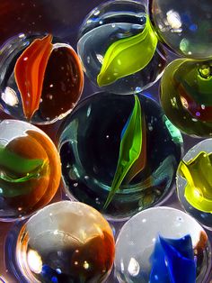 many different colored glass bowls with leaves in them