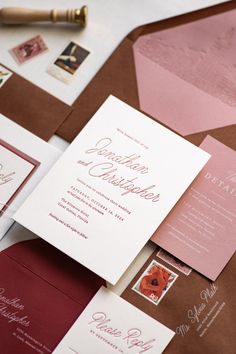 the wedding stationery is laid out on top of each other, including envelopes and stamps