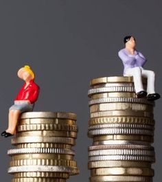 two small figurines sitting on top of stacks of coins, one is looking up at the sky