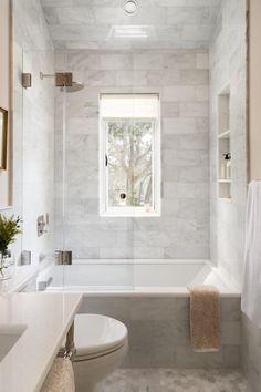 a bathroom with a toilet, sink and bathtub next to a window in the wall