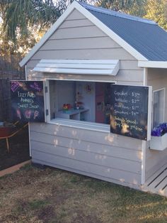 a small building with a chalkboard sign on it