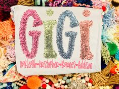 a sign that says gigi on it surrounded by beads