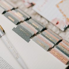 a pen sitting on top of a notebook next to some writing paper and envelopes