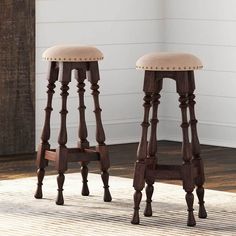 two wooden stools sitting on top of a rug