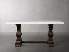 a white marble table with wooden legs on a gray floor in front of a grey wall