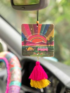 a car dashboard with a keychain hanging from it's center console and colorful tassels