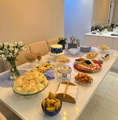 a table filled with lots of food on top of a white countertop next to a vase