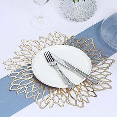 a white plate topped with two silverware on top of a table