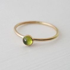 A single 4mm genuine peridot gemstone has been encased in 14k gold filled and set on a 14k gold filled stacker ring. Band measures 1.3mm thick. Stone measures 4mm. Stackable Peridot Jewelry Gift, Stackable Peridot Jewelry As Gift, Stackable Round Peridot Jewelry, Stackable Yellow Gold Peridot Jewelry, Gold Stackable Rings With Gemstones For May Birthstone, Gold Stackable Rings With May Birthstone, Stackable Green Peridot Jewelry, Green Peridot Stackable Jewelry, Dainty Green 14k Gold Stackable Rings