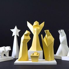 an assortment of paper sculptures on display against a black background with white and gold stars