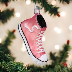 a pink sneaker ornament hanging from a christmas tree with lights in the background