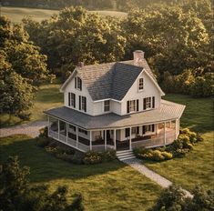 an aerial view of a large white house in the middle of some trees and grass