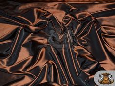 an image of a black and brown satin fabric with some gold buttons on it's side