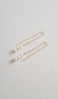 Elegant pearl drop threader earrings perfect for a minimalist bride on her wedding day. Hand crafted with a trio of genuine freshwater pearls and delicate ear wires with fine chain. Very light weight and easy to wear. Available in silver or gold. ♥ COLOR: Silver or gold with light cream colored pearls ♥ SIZE: 2 3/8" Long x 3/16" wide ♥ PRODUCTION TIME: Ready to ship out in 1-2 business days ♥ IMPORTANT: Please be sure to read over my Policy & FAQs section for more information before placing an o White Pearl Drop Threader Earrings, White Dainty Pearl Drop Threader Earrings, White Dainty Threader Earrings With Pearl Drop, Dainty White Pearl Drop Threader Earrings, Elegant Wedding Threader Earrings, Adjustable Minimalist Dangle Pearl Earrings, Pearl Threader Earrings With Pearl Drop For Weddings, Pearl Drop Threader Earrings For Wedding, Delicate Long Drop Threader Earrings For Wedding