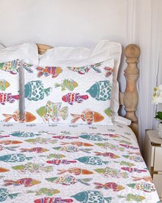 an image of a bed with colorful fish on it's cover and pillow cases