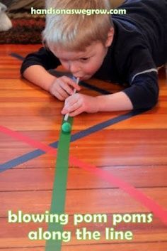 a little boy laying on the floor playing with tape