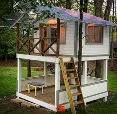 a small white house with a deck and stairs