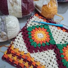 crocheted grannys and balls of yarn on a table